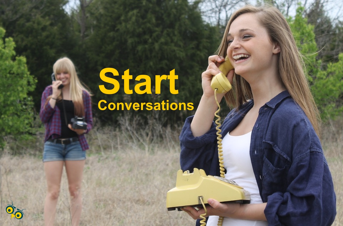 two girls having a phone conversation in a field